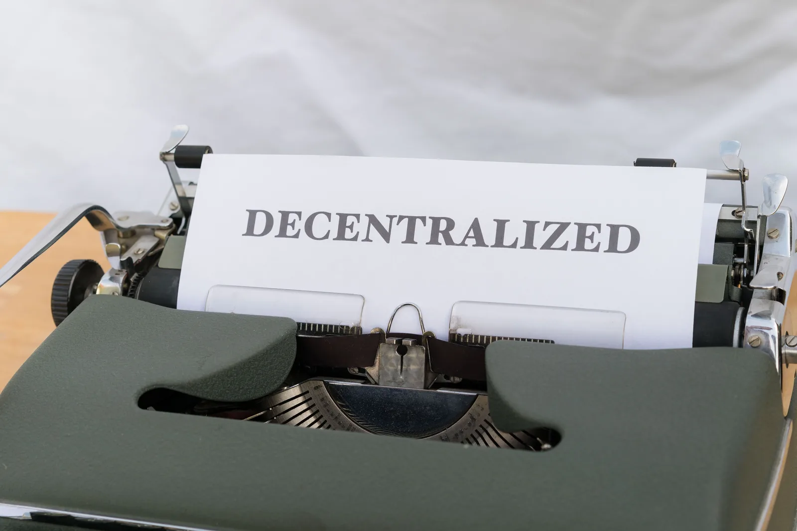 Close-up of a vintage typewriter with paper showing the word 'Decentralized'. How to assemble a decentralized networks timeline